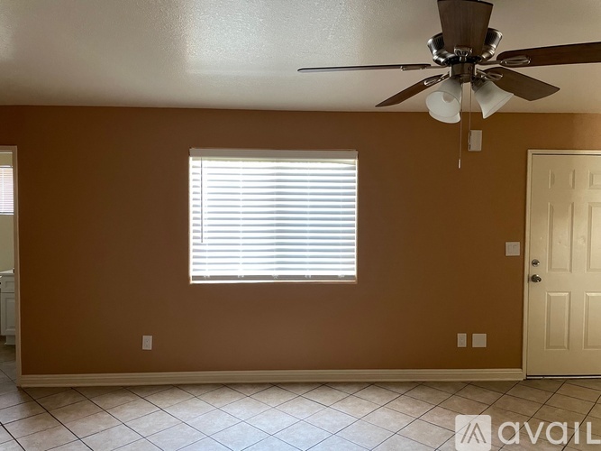 A room with a ceiling fan and a window with blinds.