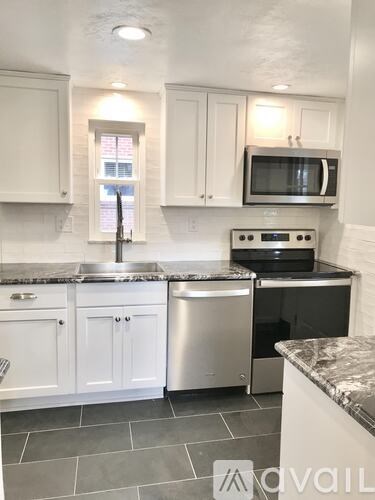 A kitchen with white cabinets and a granite countertop.