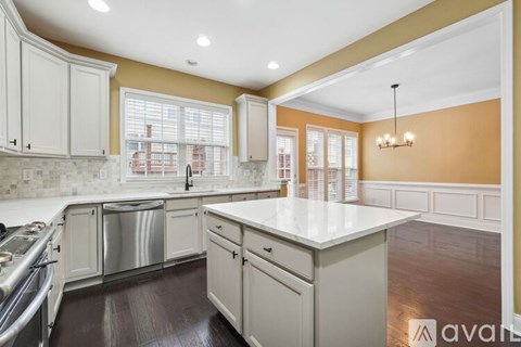 A kitchen with white cabinets and a large island.