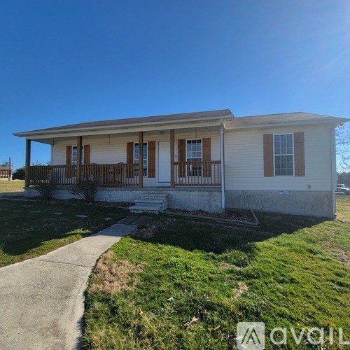 A small house with a porch and a fence.