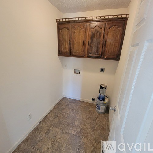 A room with wooden cabinets and a tiled floor.