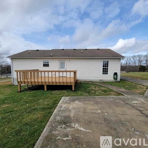 A white house with a wooden deck in front.