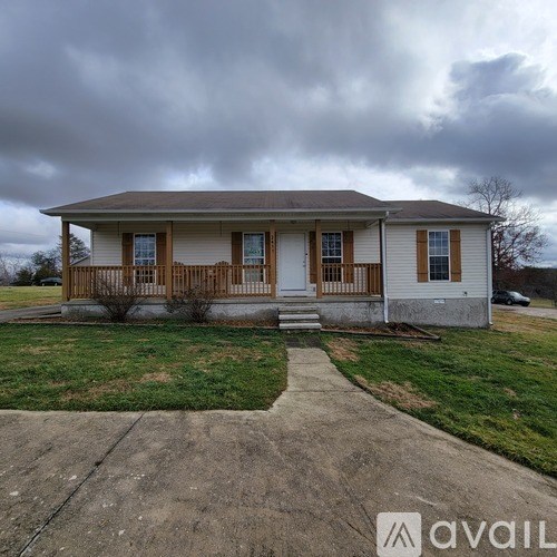 A house with a porch and a car parked in the driveway.