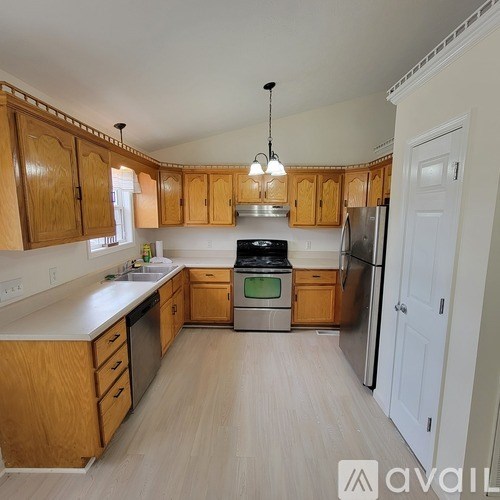 A kitchen with wooden cabinets and a stainless steel refrigerator.