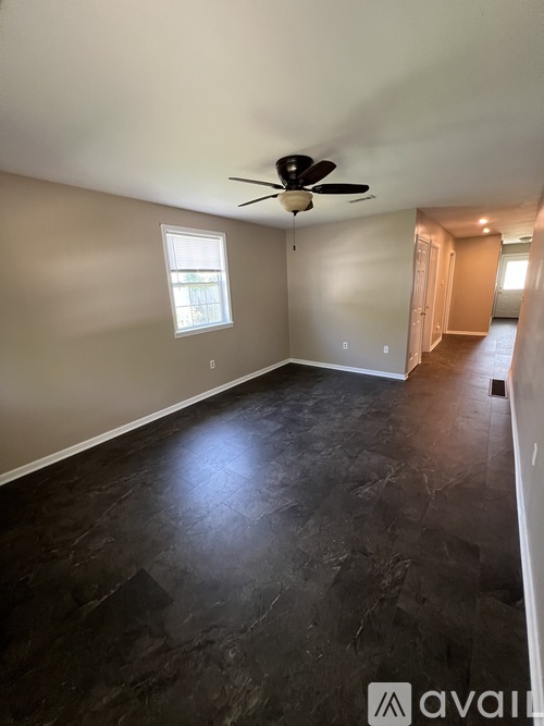 A room with a ceiling fan and a window.