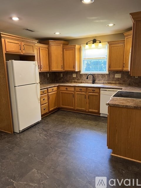 A kitchen with wooden cabinets and a white refrigerator.