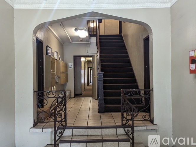 A staircase with a black carpeted runner and a metal railing.
