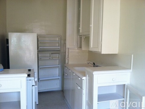 A kitchen with white appliances and cabinets.
