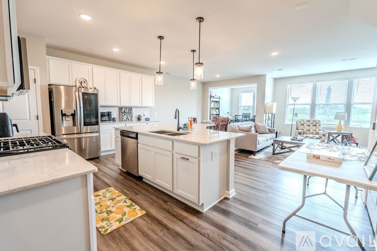 A kitchen with white cabinets and a wooden floor.