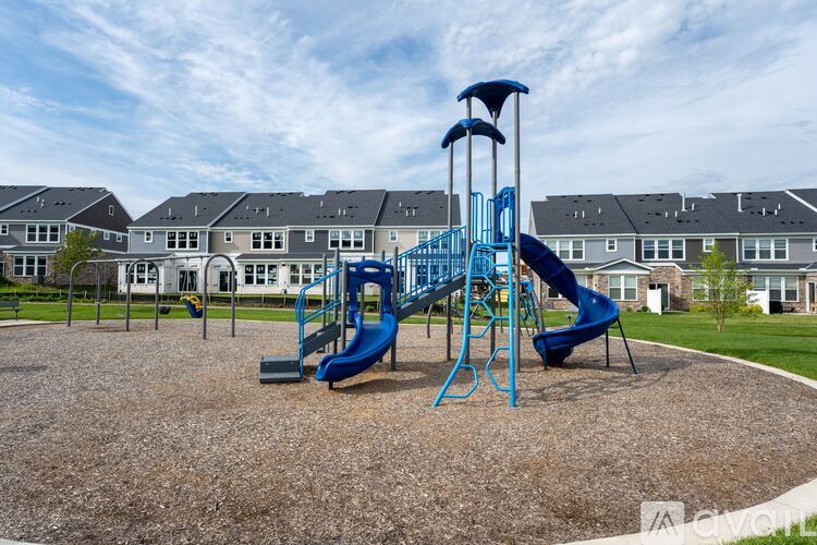 A playground with a blue slide and a yellow slide.