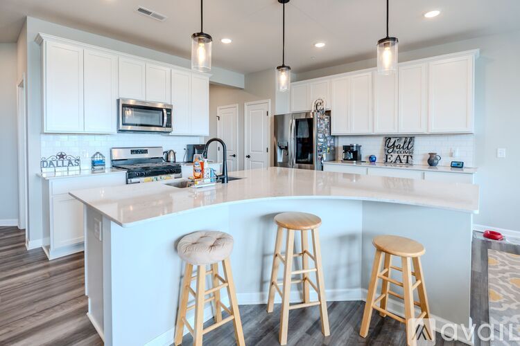A kitchen with a white counter and bar stools.