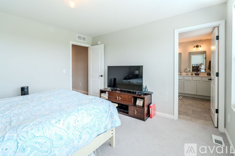 A bedroom with a bed, dresser, and mirror.