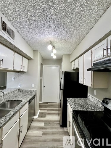 A kitchen with black appliances and granite countertops.
