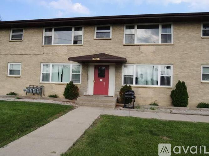 A brick building with a red door and a sign that says "available".