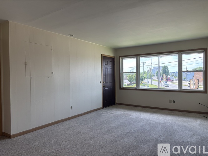 Empty room with a door and a window overlooking a street.