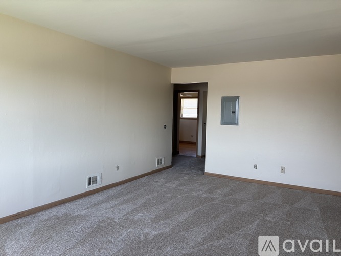 A room with a carpeted floor and a door leading to another room.