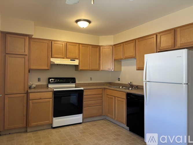 A kitchen with wooden cabinets and a white refrigerator.