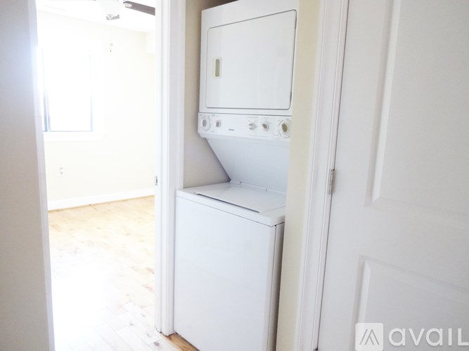 A white dishwasher is sitting in a narrow hallway.