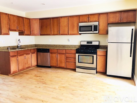 A kitchen with wooden cabinets and a white fridge.