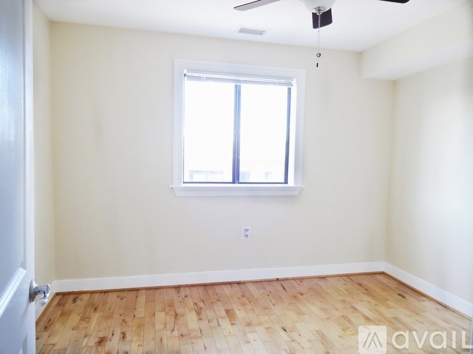 A room with a window and wooden flooring is available for rent.