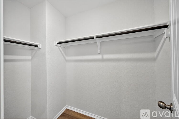 A white closet with two shelves and a door.