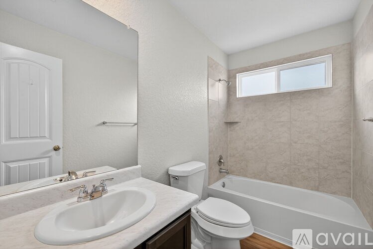 A bathroom with a white sink, toilet, and bathtub.