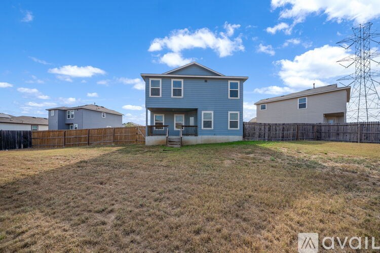 A blue house with a fence in front of it.