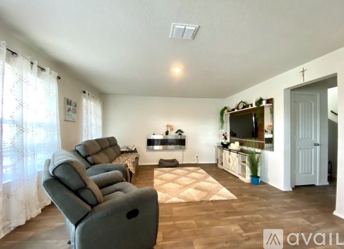 A living room with a row of grey sofas and a television.