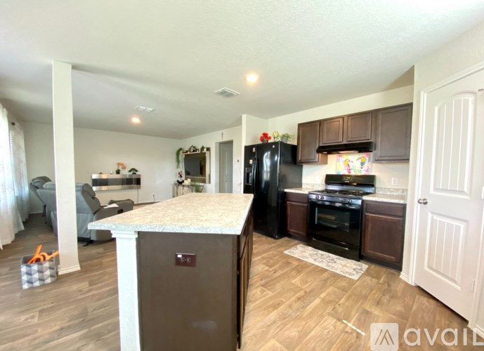 A kitchen with a black refrigerator and a white countertop.