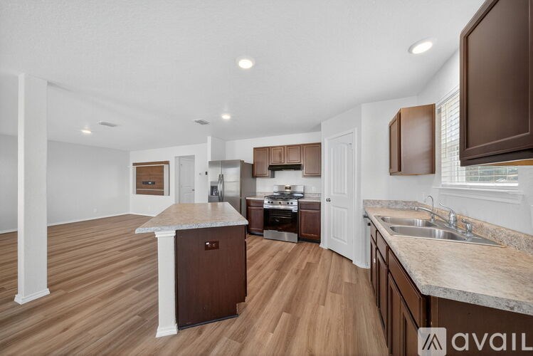 A kitchen with a black fridge and a white island.
