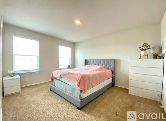 A bedroom with a large bed and a carpeted floor.