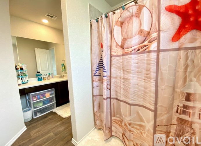 A shower curtain with a beach theme is hanging in a bathroom.