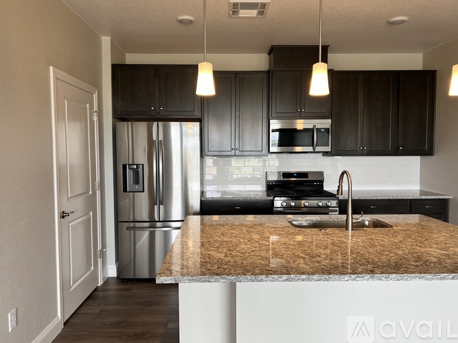 A kitchen with a granite countertop and stainless steel appliances.