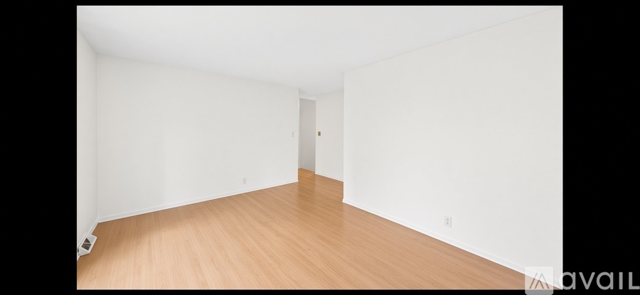 A room with a ceiling fan and wooden flooring.