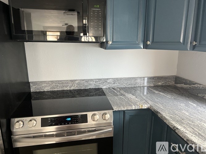 A modern kitchen with a stainless steel oven and a microwave above it.