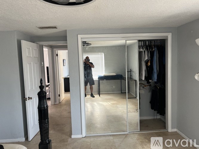 A man is taking a photo in a mirrored closet.
