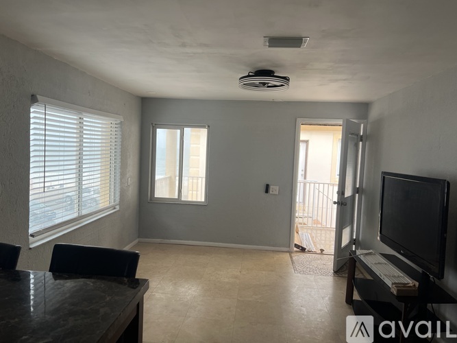 A living room with a television and a sliding glass door.