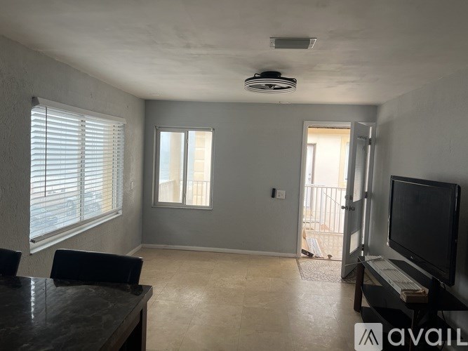 A living room with a television and a sliding glass door.
