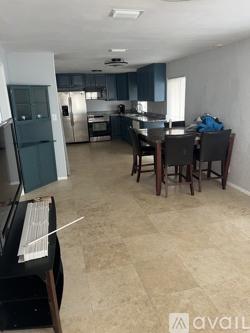 A kitchen with a dining table and chairs.