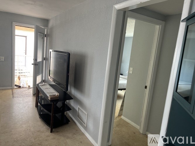 A room with a television and a desk.