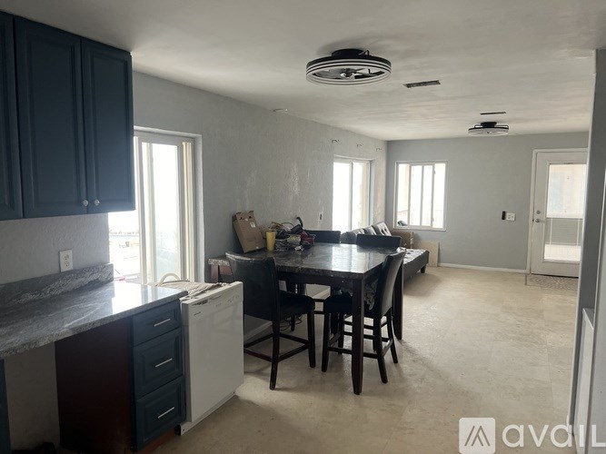 A kitchen with dark blue cabinets and a white dishwasher.