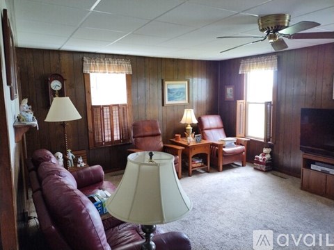 A living room with a red leather couch and a white lamp.