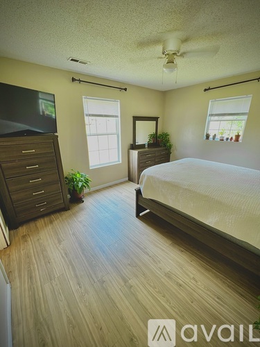 A bedroom with a bed, dresser, and mirror.