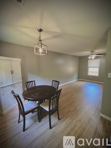 A dining room with a table and chairs.