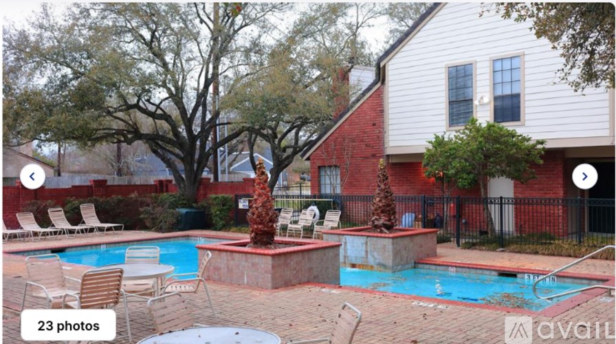 A pool surrounded by a red fence and a tree.