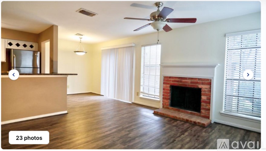 A living room with a fireplace and a fan.