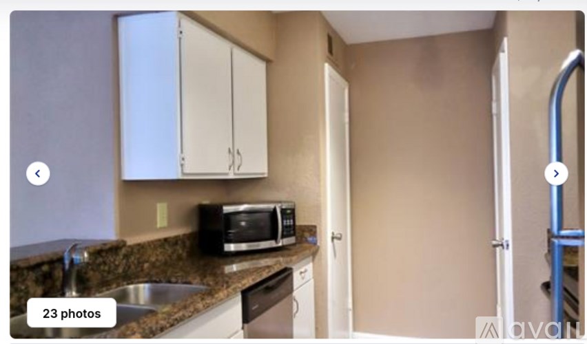 A kitchen with a sink, microwave, and cabinets.