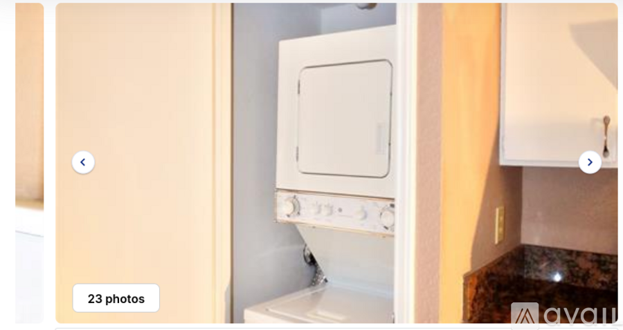 A white oven is built into a kitchen cabinet.