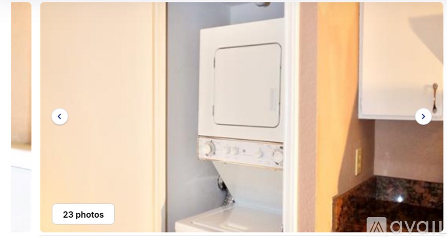 A white oven is built into a kitchen cabinet.