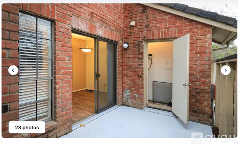 A red brick house with a black door and a window.